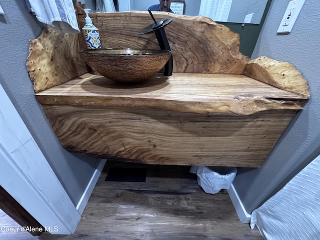 10320 N Payment Peak Rd, Hauser, ID 83854 - bathroom view of a sink, baseboards, wood finished floors, and a textured wall