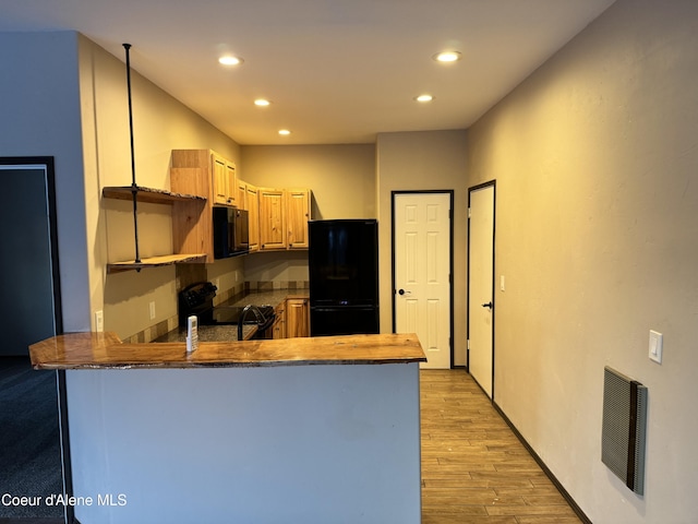 10320 N Payment Peak Rd, Hauser, ID 83854 - kitchen featuring black appliances, a peninsula, recessed lighting, light wood-style flooring, and light brown cabinetry
