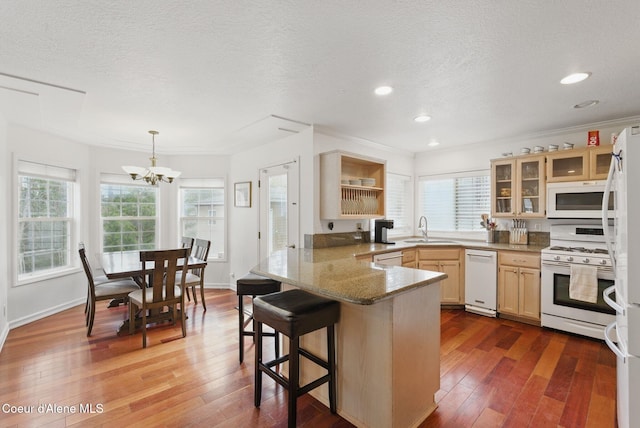 2123 Browning Way, Sandpoint, ID 83864 - kitchen featuring a textured ceiling, white appliances, a sink, a peninsula, and hardwood / wood-style floors