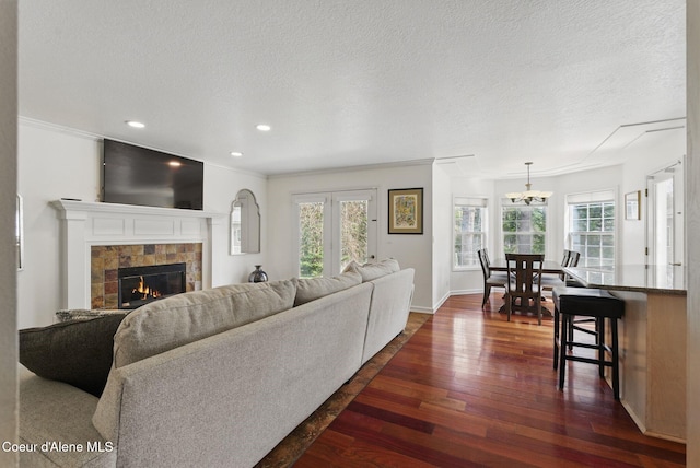 2123 Browning Way, Sandpoint, ID 83864 - living room with a textured ceiling, dark wood-style flooring, a tile fireplace, and plenty of natural light