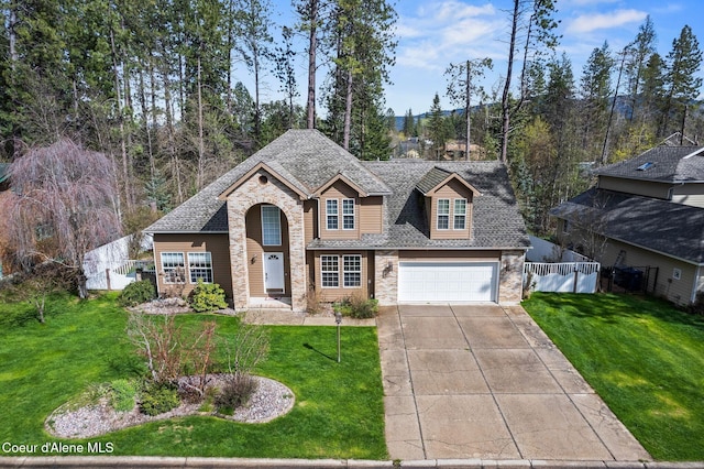 2123 Browning Way, Sandpoint, ID 83864 - traditional-style house featuring driveway, fence, a garage, stone siding, and a front lawn
