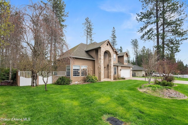 2123 Browning Way, Sandpoint, ID 83864 - traditional-style home featuring concrete driveway, roof with shingles, a front lawn, and an attached garage