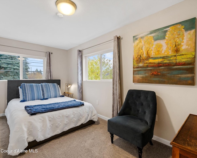 carpeted bedroom featuring multiple windows and baseboards
