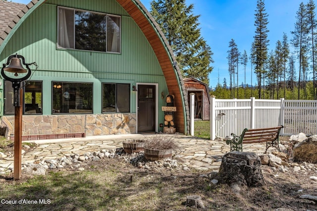 762 Reeder Bay Rd, Nordman, ID 83848 - rear view of house featuring fence and stone siding