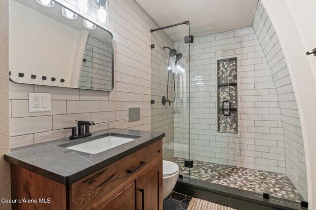 762 Reeder Bay Rd, Nordman, ID 83848 - full bath with a stall shower, tile patterned floors, tile walls, toilet, and decorative backsplash
