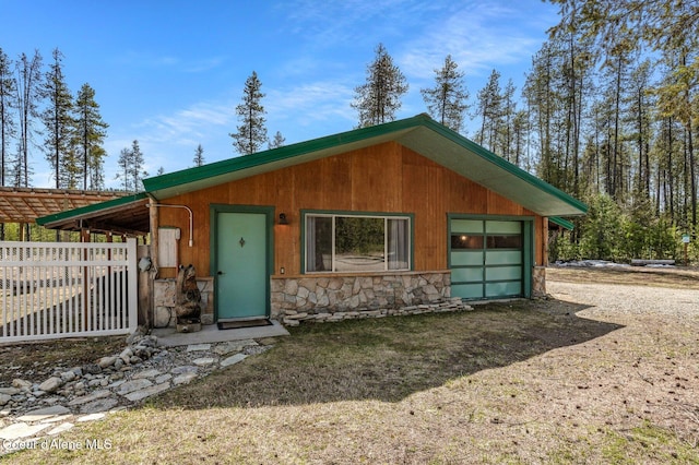 762 Reeder Bay Rd, Nordman, ID 83848 - view of front facade featuring stone siding, dirt driveway, and fence