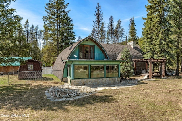 762 Reeder Bay Rd, Nordman, ID 83848 - rear view of house with a pergola, a fire pit, a chimney, roof with shingles, and a gambrel roof