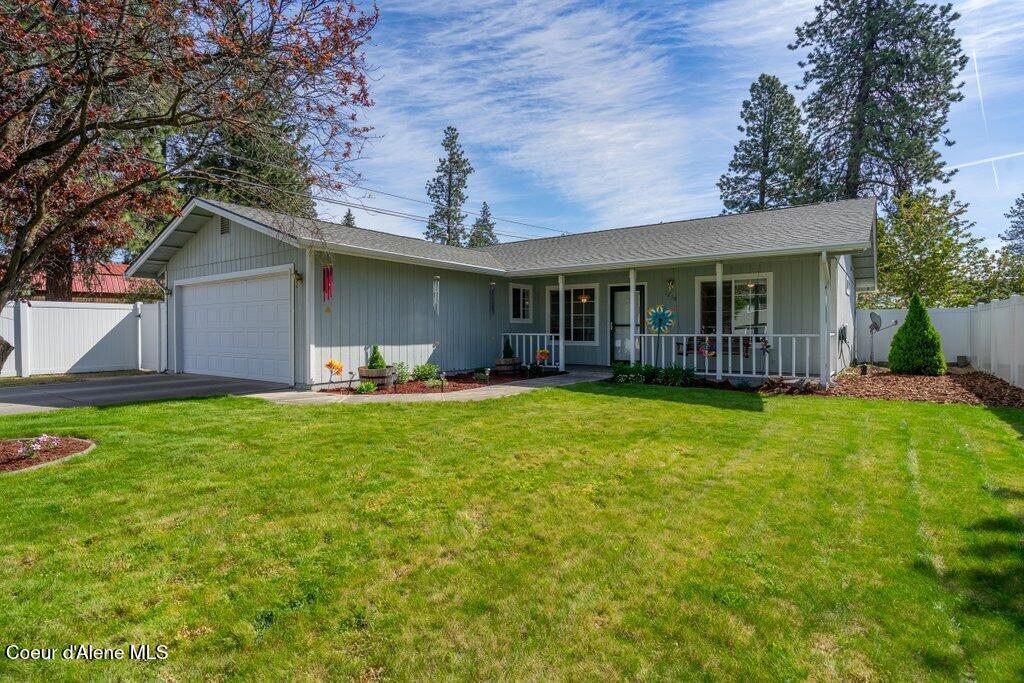 1218 N Catherine St, Post Falls, ID 83854 - ranch-style home featuring covered porch, a garage, driveway, and board and batten siding