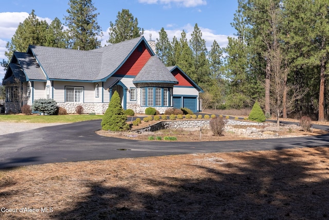 25929 E Idaho Pines Ln, Newman Lake, WA 99025 - craftsman-style home with stone siding, roof with shingles, and a garage