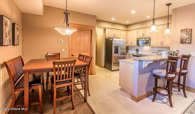2051 N Main St # 217, Coeur Dalene, ID 83814 - kitchen featuring appliances with stainless steel finishes, light stone countertops, a peninsula, decorative backsplash, and decorative light fixtures