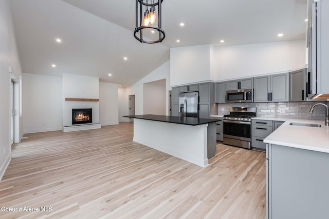 215 White Cloud Dr, Sandpoint, ID 83864 - kitchen with appliances with stainless steel finishes, a sink, gray cabinets, open floor plan, and high vaulted ceiling