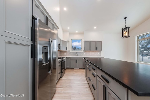 215 White Cloud Dr, Sandpoint, ID 83864 - kitchen with stainless steel fridge with ice dispenser, gray cabinetry, range with gas stovetop, a sink, and tasteful backsplash