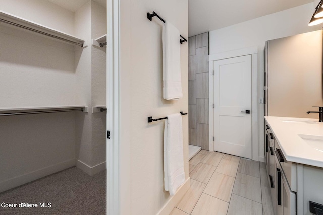 215 White Cloud Dr, Sandpoint, ID 83864 - bathroom featuring a tile shower, double vanity, and a spacious closet