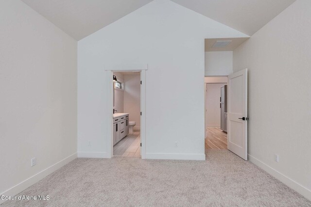 215 White Cloud Dr, Sandpoint, ID 83864 - unfurnished bedroom with vaulted ceiling, light carpet, baseboards, and ensuite bath