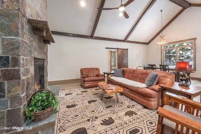 215 White Cloud Dr, Sandpoint, ID 83864 - living area with a barn door, wood finished floors, high vaulted ceiling, beam ceiling, and a fireplace