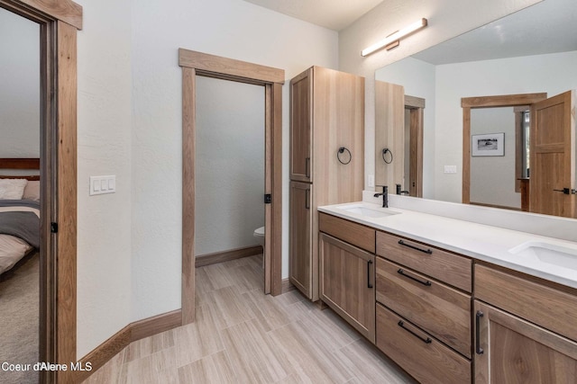 215 White Cloud Dr, Sandpoint, ID 83864 - bathroom featuring toilet, double vanity, baseboards, and ensuite bath