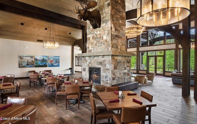 215 White Cloud Dr, Sandpoint, ID 83864 - dining space featuring hardwood / wood-style floors, high vaulted ceiling, beamed ceiling, a fireplace, and a chandelier