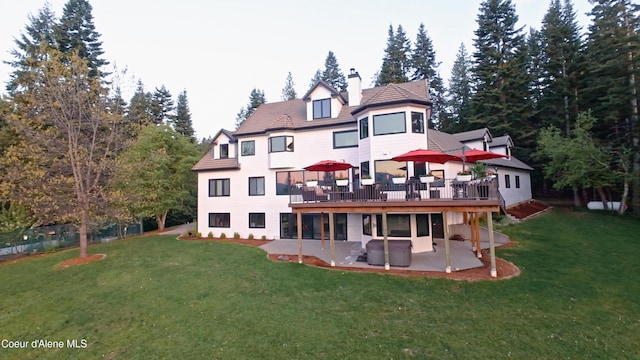 15818 N Morgan Ln, Hayden, ID 83835 - back of house featuring a patio, a chimney, a lawn, and a deck