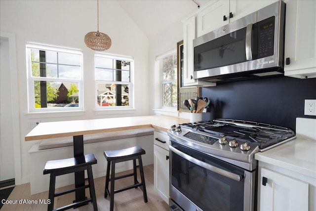 232 Pomrankey Ln, Dover, ID 83825 - kitchen with appliances with stainless steel finishes, lofted ceiling, white cabinetry, light countertops, and pendant lighting