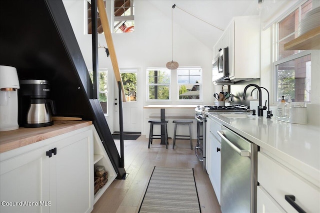 232 Pomrankey Ln, Dover, ID 83825 - kitchen with appliances with stainless steel finishes, white cabinets, healthy amount of natural light, and high vaulted ceiling