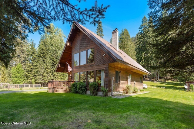 view of home's exterior with a wooden deck, a chimney, and metal roof