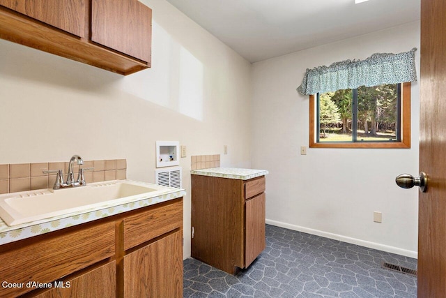 laundry room featuring hookup for a washing machine, cabinet space, and baseboards
