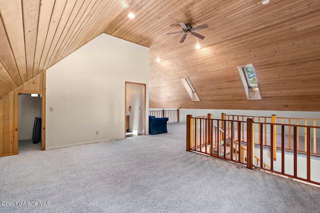additional living space with wooden ceiling, a skylight, ceiling fan, carpet, and baseboards