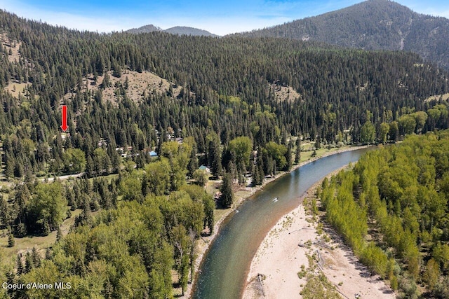aerial overview of property's location featuring a heavily wooded area and a water and mountain view