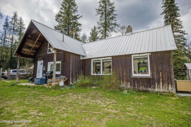 847 Willford Rd, Cocolalla, ID 83813 - back of property with metal roof, a yard, and a chimney