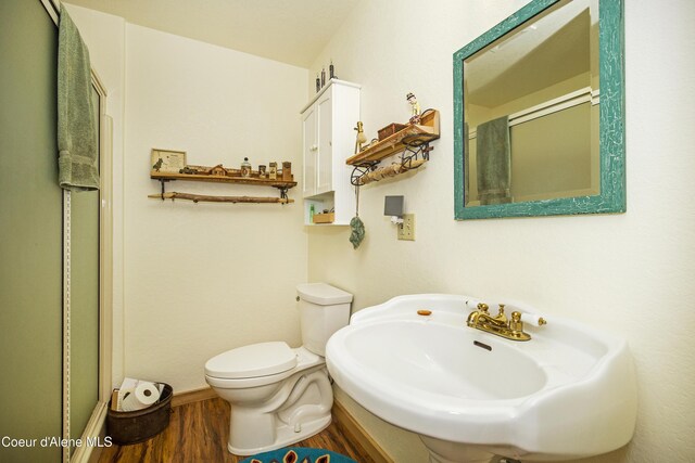 847 Willford Rd, Cocolalla, ID 83813 - bathroom featuring wood finished floors, toilet, a sink, and a shower with shower door