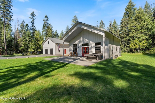 view of front of property featuring a garage, french doors, a front yard, and a patio area