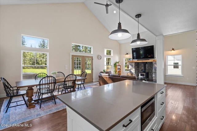 kitchen with stainless steel microwave, dark wood-type flooring, high vaulted ceiling, white cabinets, and french doors