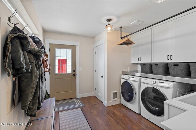 laundry room with washing machine and clothes dryer, cabinet space, baseboards, and dark wood-style floors