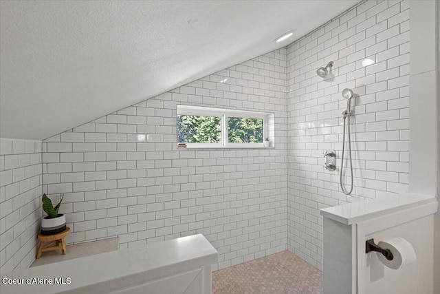 bathroom with lofted ceiling, walk in shower, and tile walls