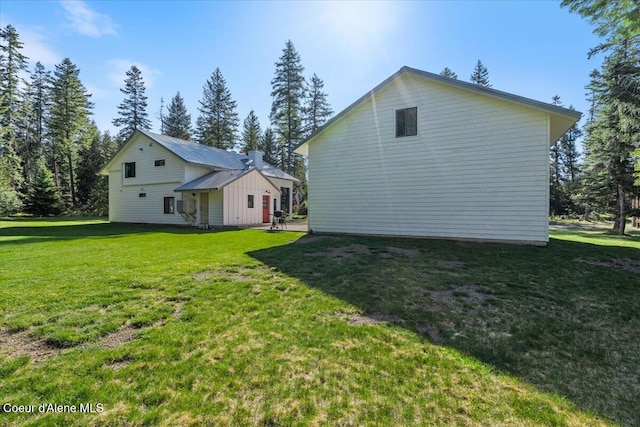 view of side of home with a yard