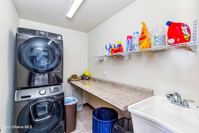 laundry room with stacked washing machine and dryer, wood finished floors, and baseboards