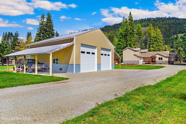 garage featuring a detached garage and a view of trees