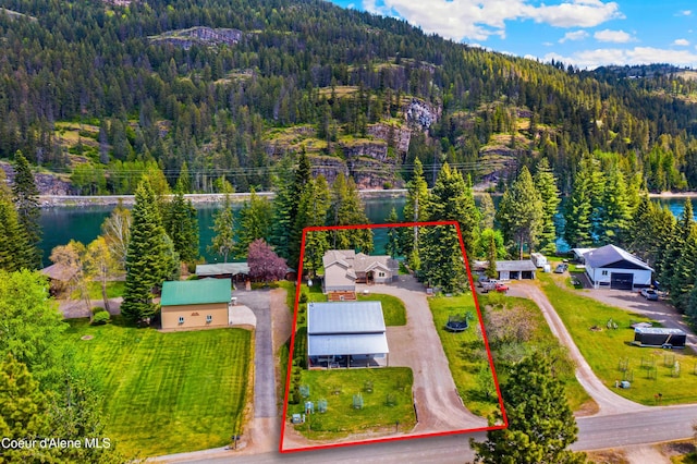 aerial overview of property's location featuring a forest, property parcel outlined, and a nearby body of water