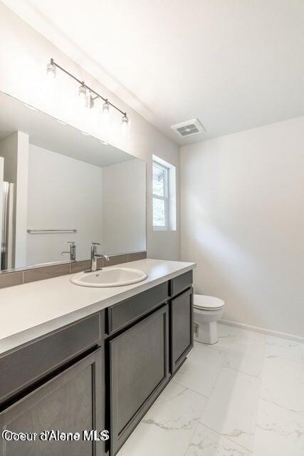 81 Parkland Dr, Blanchard, ID 83804 - bathroom with marble look tile flooring, toilet, and vanity