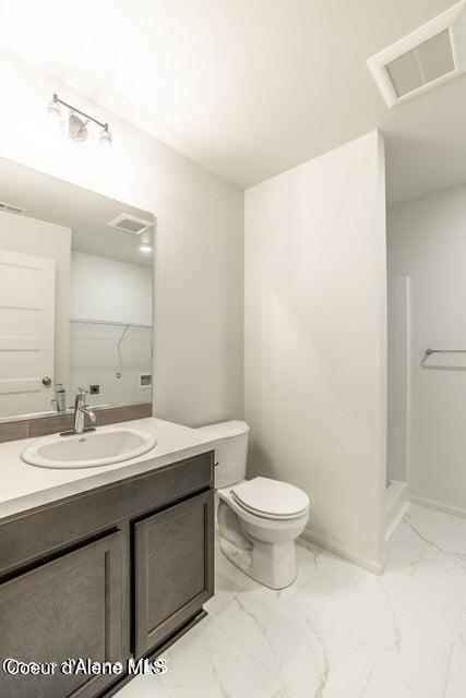 81 Parkland Dr, Blanchard, ID 83804 - bathroom with vanity, toilet, marble finish flooring, and a shower