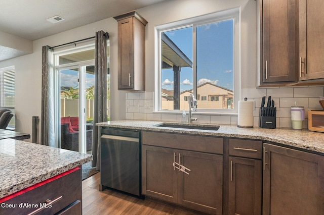 1749 N Minam Loop, Post Falls, ID 83854 - kitchen with dishwasher, a sink, wood finished floors, decorative backsplash, and light stone countertops