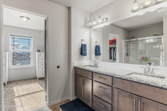 1749 N Minam Loop, Post Falls, ID 83854 - bathroom with double vanity, a shower stall, a walk in closet, and baseboards