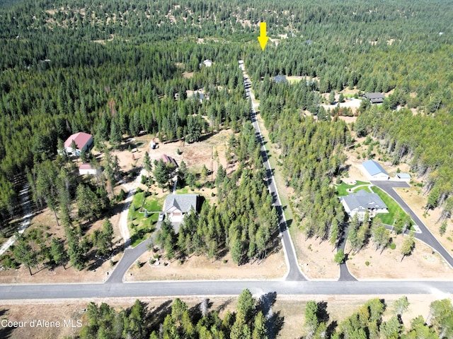 aerial view of property and surrounding area featuring a heavily wooded area