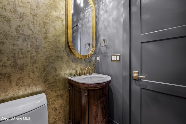 half bath featuring vanity and toilet