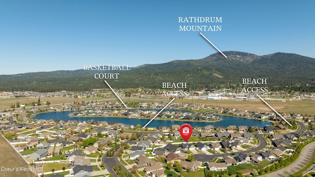 aerial view of property and surrounding area featuring a water and mountain view and nearby suburban area