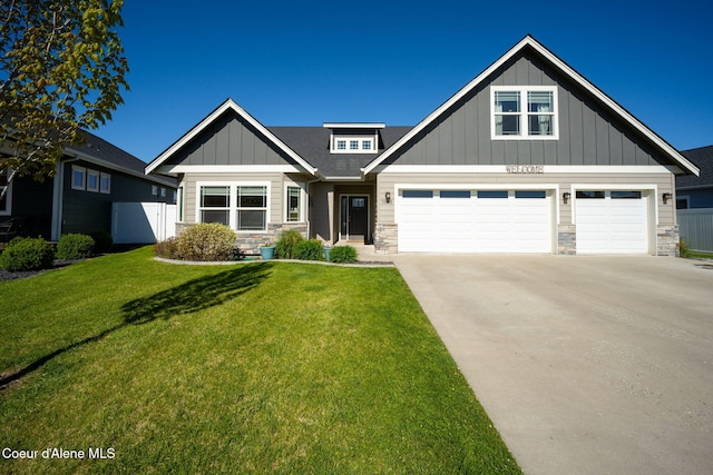 craftsman inspired home with stone siding, board and batten siding, a front yard, and driveway