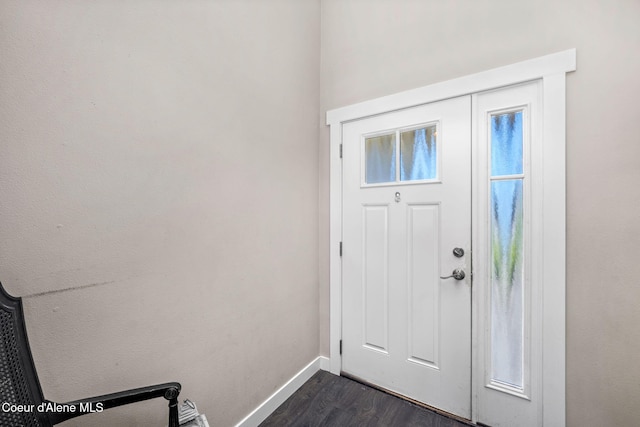 foyer entrance with dark wood-style flooring and baseboards