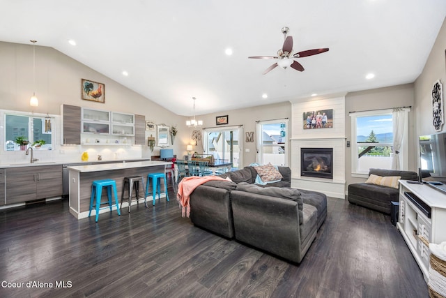 living area featuring dark wood finished floors, a ceiling fan, recessed lighting, a chandelier, and a large fireplace