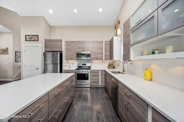 kitchen with stainless steel appliances, a sink, tasteful backsplash, light stone counters, and recessed lighting