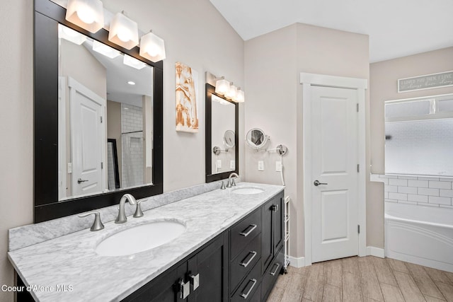 full bathroom with wood tiled floors, double vanity, baseboards, and a tub to relax in
